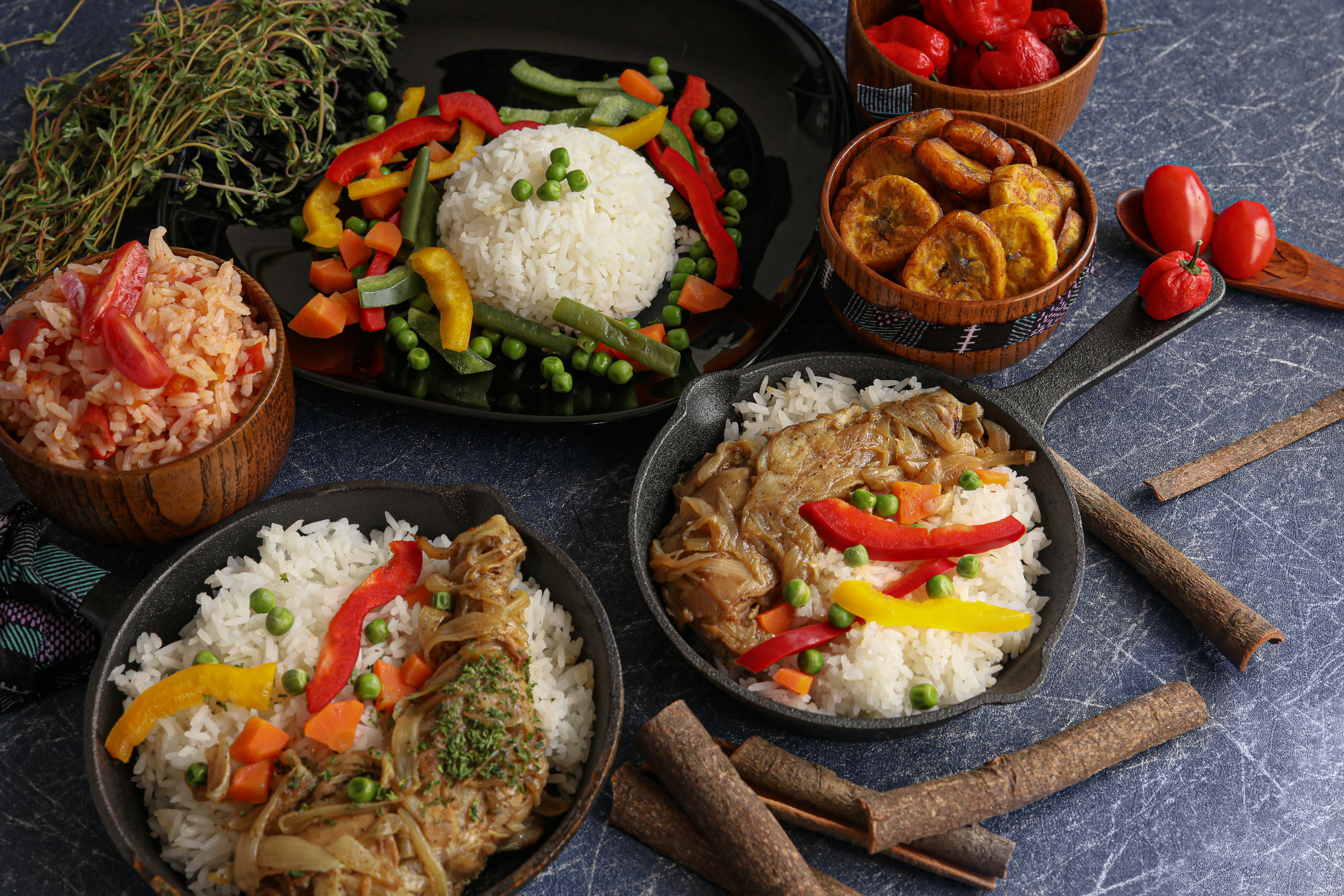 Table dressée avec riz, poulet yassa, légumes et plantains