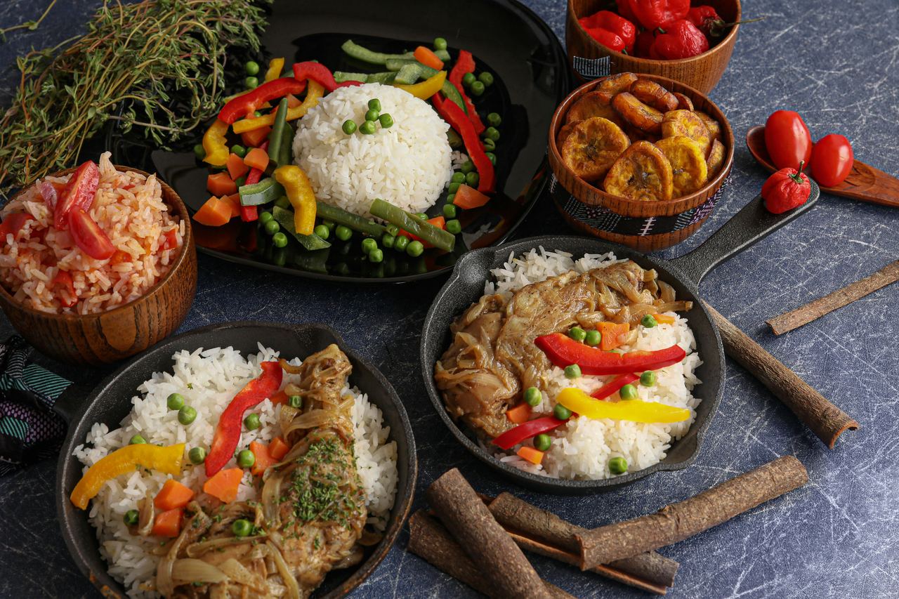 Table set with rice, yassa chicken, vegetables and plantains